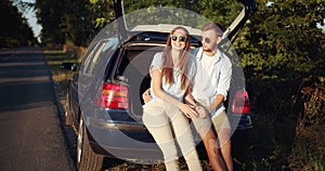 Couple Sitting in Car Trunk and Relaxing