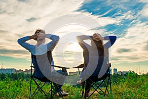 Couple sitting in chairs and admire the sunrise