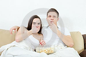 Couple sitting on the couch in living room at home covered with