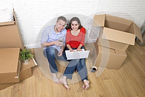 Couple sitting on floor moving in a new house or apartment flat