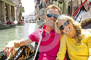 Couple sitting in gondola and smiling