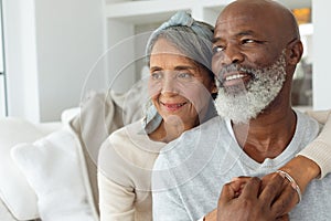 Couple sitting inside a room smiling.