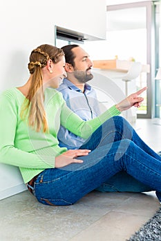 Couple sitting on living room floor enjoying view