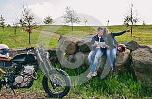 Couple sitting looking at a map with motorcycle