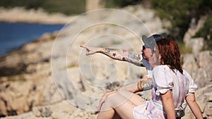 A couple sitting on a mountain and sees seascapes