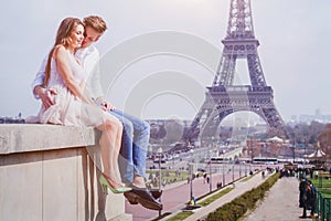 Couple sitting near Eiffel Tower in Paris, honeymoon in Europe