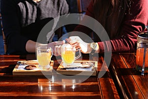 Couple sitting near table with sea-buckthorn broth in cafe discu