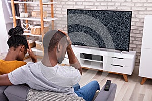 Couple Sitting Near Television With No Signal