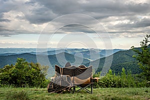 Couple sitting overlooking the Blue Ridge Mountains, Looking Glass Rock near Brevard, North Carolina, USA