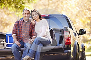 Couple Sitting In Pick Up Truck On Camping Holiday