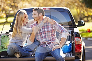 Couple Sitting In Pick Up Truck On Camping Holiday