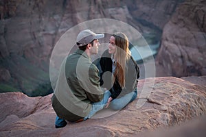 couple sitting on the rock in the desert of Horseshoe Bend, blue hour sunset, the sun goes down