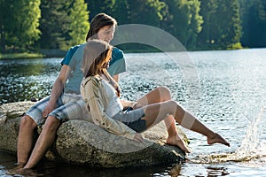 Couple sitting on rock sharing romantic moment