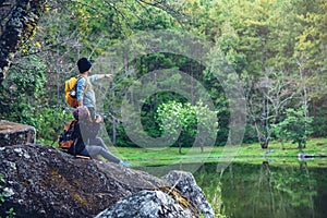 Couple sitting on rocks and taking pictures nature, flowers. at Paphiopedilum orchid conservation center