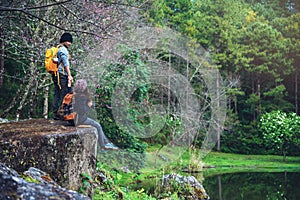 Couple sitting on rocks and taking pictures nature, flowers. at Paphiopedilum orchid conservation center