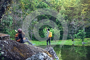 Couple sitting on rocks and taking pictures nature, flowers. at Paphiopedilum orchid conservation center