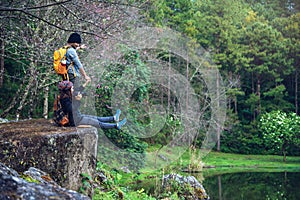 Couple sitting on rocks and taking pictures nature, flowers. at Paphiopedilum orchid conservation center