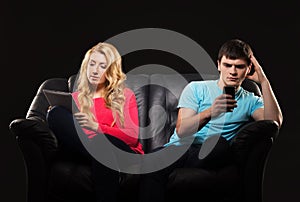 A couple sitting separately with smartphones