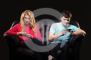 A couple sitting separately with smartphones photo