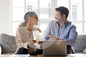 Couple sitting on sofa busy with manage household budget