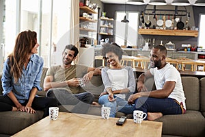 Couple Sitting On Sofa With Friends At Home Talking