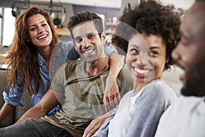 Couple Sitting On Sofa With Friends At Home Talking