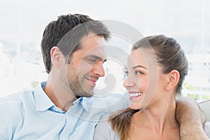 Couple sitting on the sofa smiling at each other