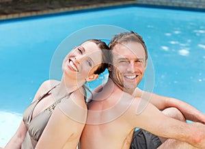 Couple sitting beside the swimming pool