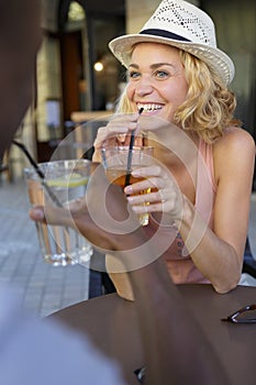 couple sitting at table enjoying outdoor summer drink at pub