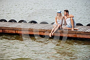 Couple sitting and talking on pier