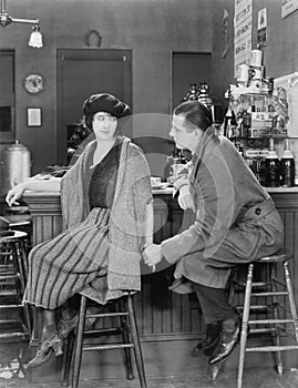 Couple sitting together at a bar looking at each other