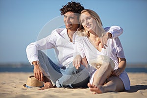 couple sitting together on beach and enjoying tranquillity