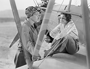 Couple sitting together on a plane looking at each other