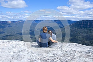 Couple sitting on top of mountain