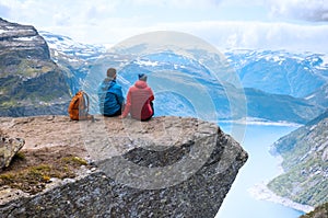 Couple sitting view on the way to Trolltunga, Norway Concept of freedom and success