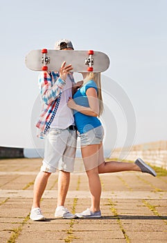 Couple with skateboard kissing outdoors