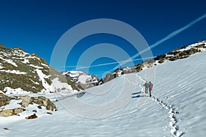 Couple on ski tour next to glacier lakes with scenic view on Hoher Sonnblick in High Tauern mountains in Carinthia, Salzburg,