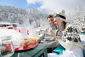 Couple of skiers having lunch break on the slopes