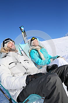 Couple of skiers sunbathing