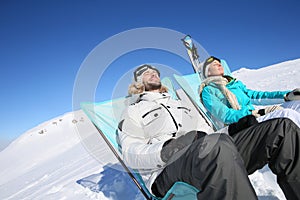 Couple of skiers taking a break sunbathing