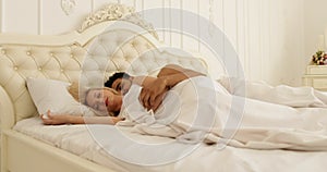 Couple sleep lying on bed man hug woman home white modern bedroom