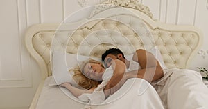 Couple sleep lying on bed man hug woman home white modern bedroom