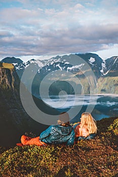 Couple in sleeping bags on a bivouac in Norway mountains with camping travel gear. Friends hiking photo