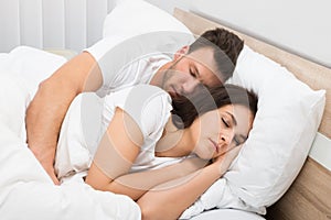 Couple sleeping on bed