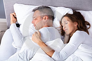 Couple Sleeping On Bed With Blanket