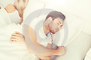 Couple sleeping in bed at home