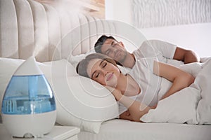 Couple sleeping in bedroom with air humidifier