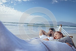 Couple sleeping on hammock at beach