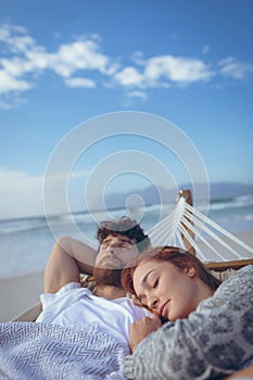 Couple sleeping on hammock at beach