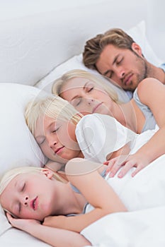 Couple sleeping with their children